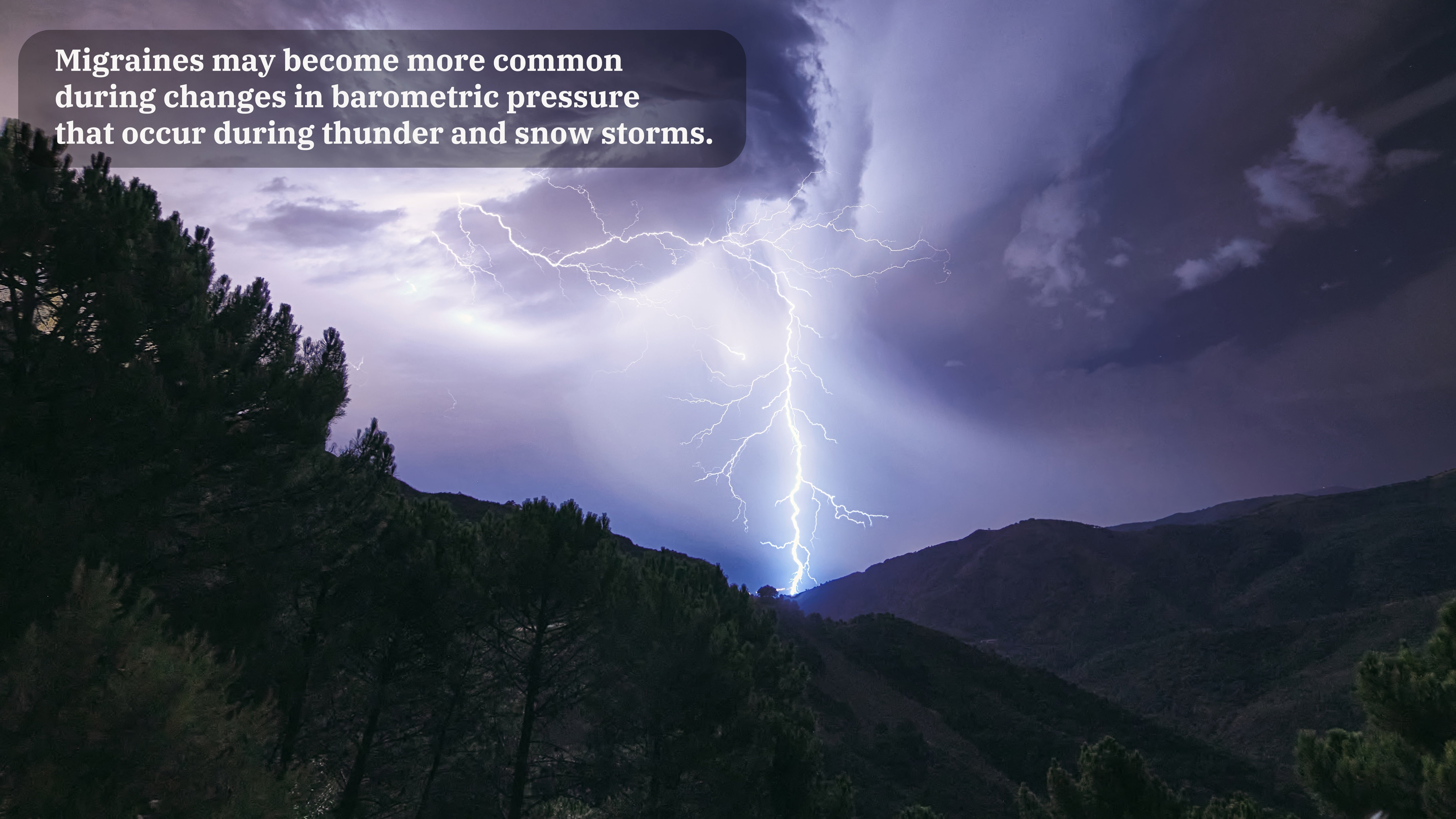 A lightning bolt is seen erupting from cloudy skies into dark trees and mountains. A caption on the image reads "Migraines may become more common during changes in barometric pressure that occur during thunder and snow storms."