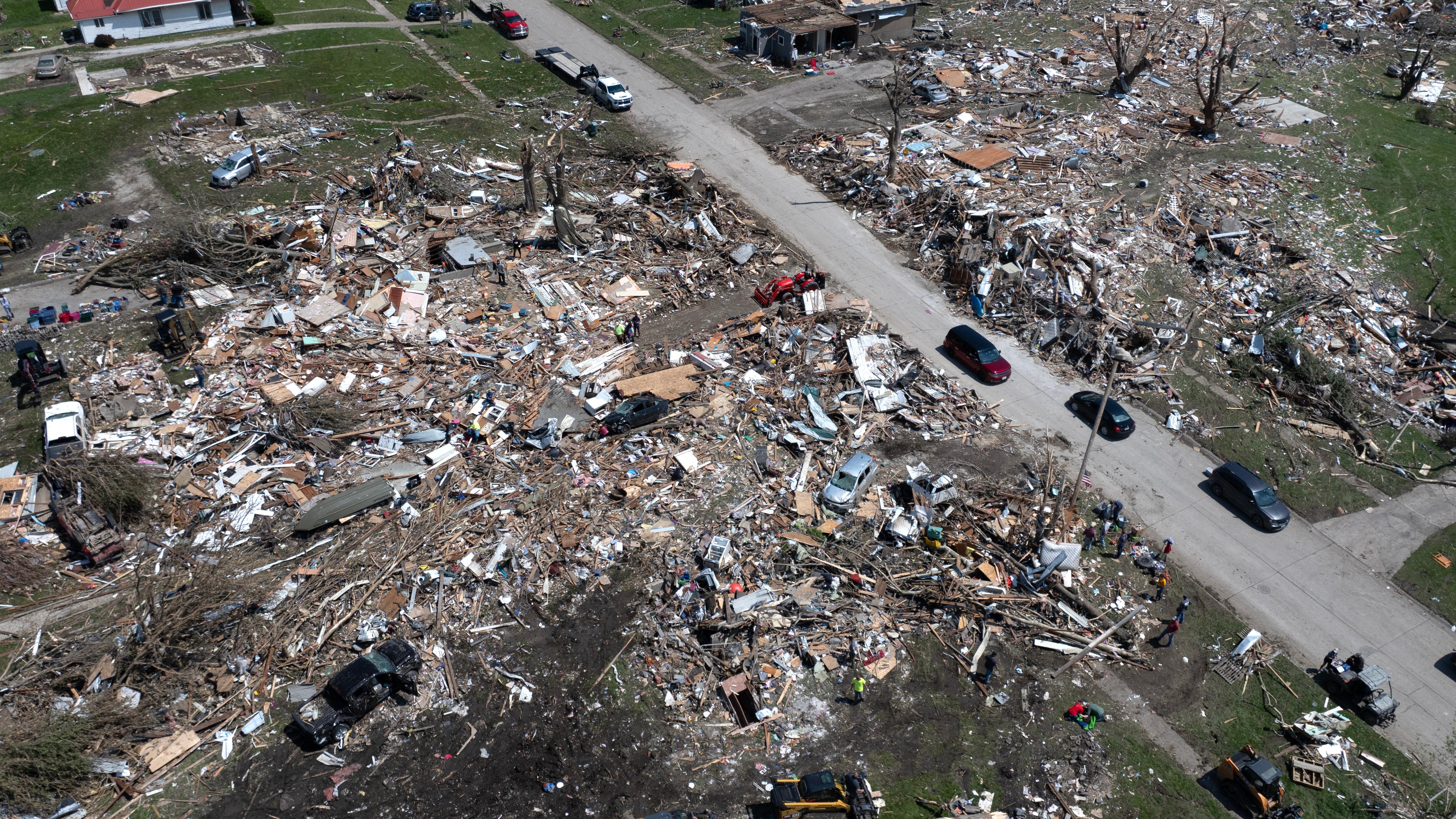 An aerial photo shows tornado damage on either side of a road.