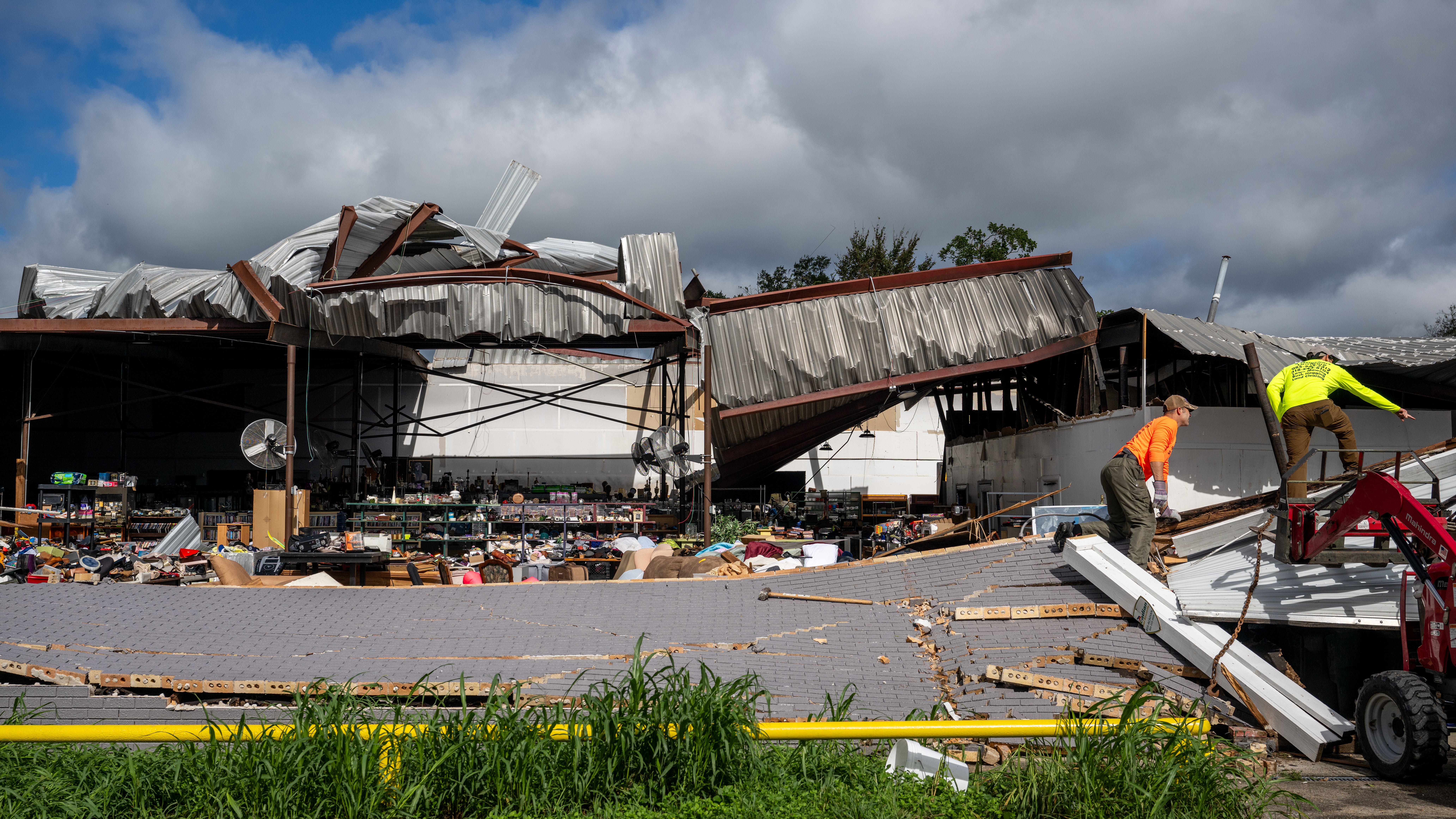 The roof of a warehouse is torn open and the interior is revealed.