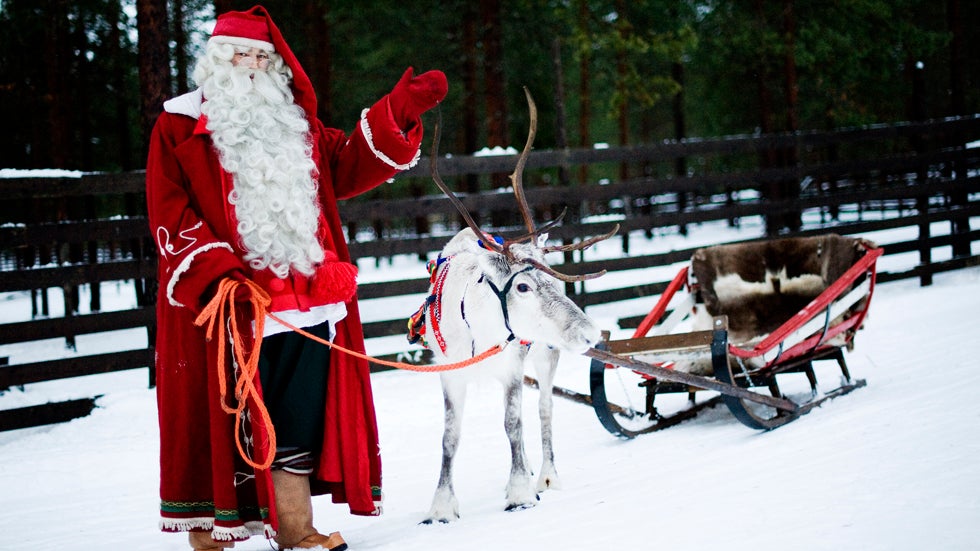 Santa Claus waves as he stands with  a reindeer and sled outside Rovaniemi, Finnish Lapland. (Jonathan Nackstrand/AFP/Getty Images)