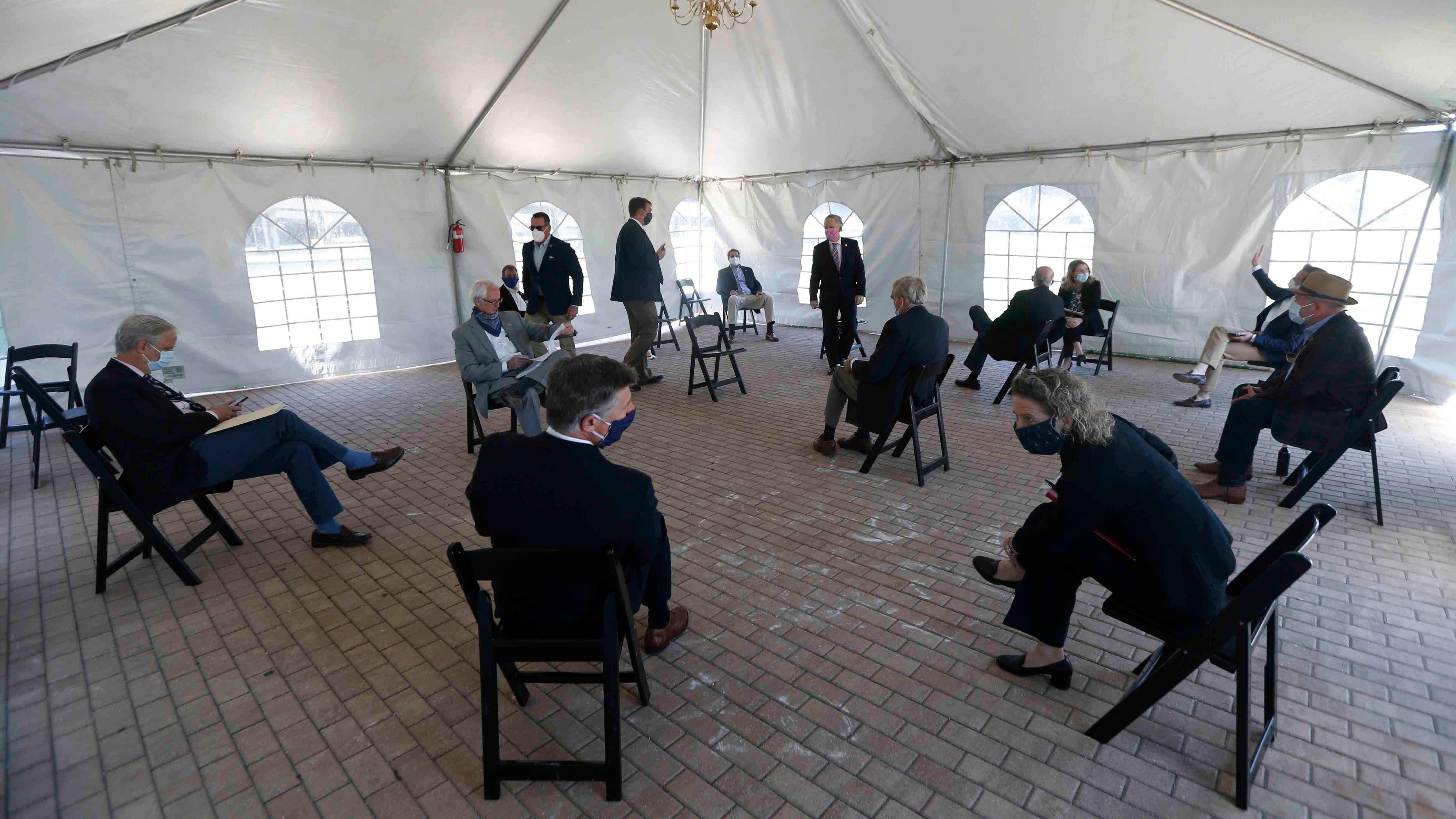 Virginia State Senator Thomas Norment, R-James City County, top center, gathers his caucus in a caucus tent as they prepare for the reconvene session at the Science Museum of Virginia Wednesday April 22, 2020, in Richmond, Va. The Senate is meeting in a remote location due to COVID-19 social distancing restrictions. (AP Photo/Steve Helber, Pool)