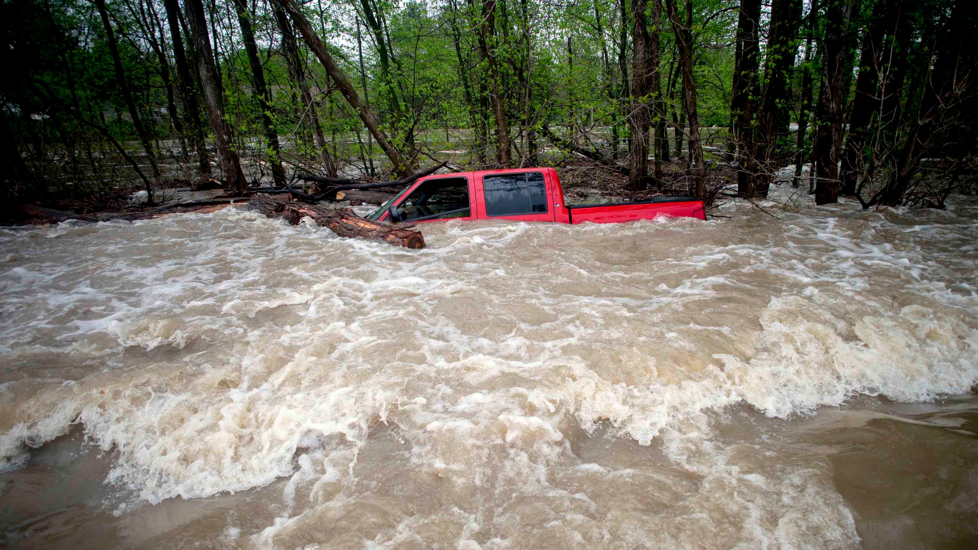 Tittabawassee Fire and Rescue rescued the driver from this red pickup truck on Norh Gleaner Road near its intersection with Tittabawassee Road on Tuesday, May 19, 2020 in Saginaw County, Mich. The truck was swept off of the road by standing water. (Jake May/The Flint Journal via AP)/