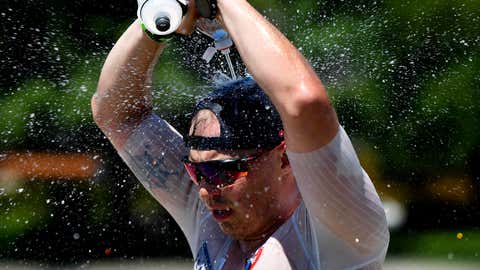 A competitor dumps icy water over his head at an aid station during the marathon portion of the 2021 Coeur d'Alene Ironman on Sunday, June 27, 2021, in Coeur d'Alene, Idaho. (Tyler Tjomsland/The Spokesman-Review via AP)