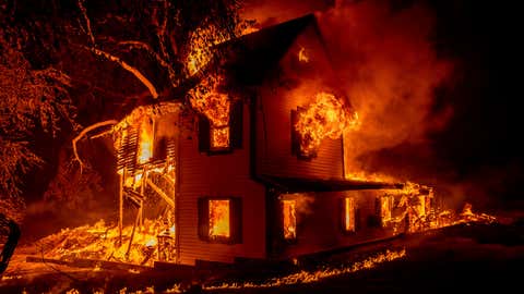 A home burns on Jeters Road as the Dixie fire jumps Highway 395 south of Janesville, Calif., on Monday, Aug. 16, 2021. Critical fire weather throughout the region threatens to spread multiple wildfires burning in Northern California. (AP Photo/Ethan Swope)