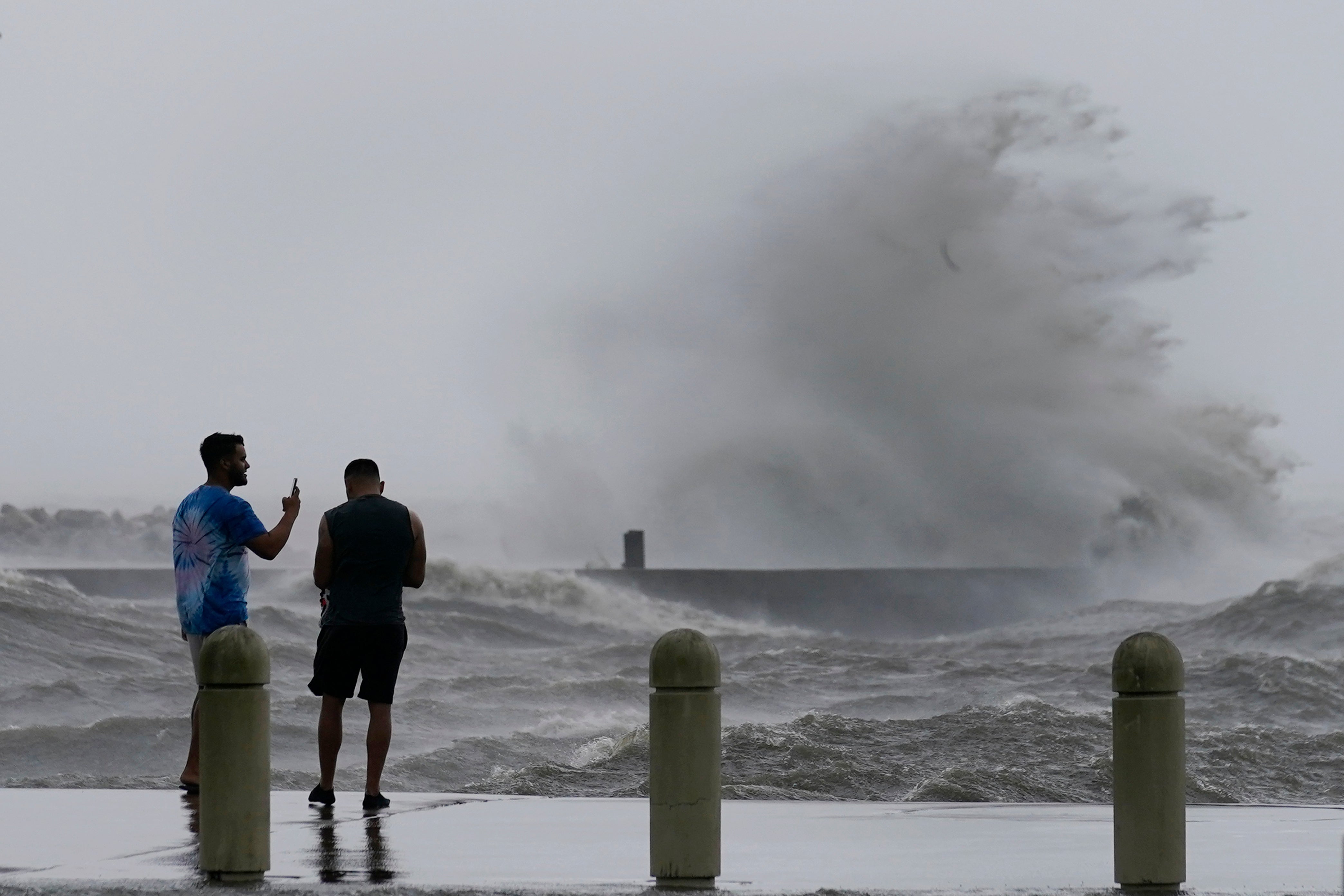 Jesse Perez, right, and Sergio Hijuelo check out the high waves on Lake Pontchartrain as Hurricane Ida nears, Sunday, Aug. 29, 2021, in New Orleans. (AP Photo/Gerald Herbert)