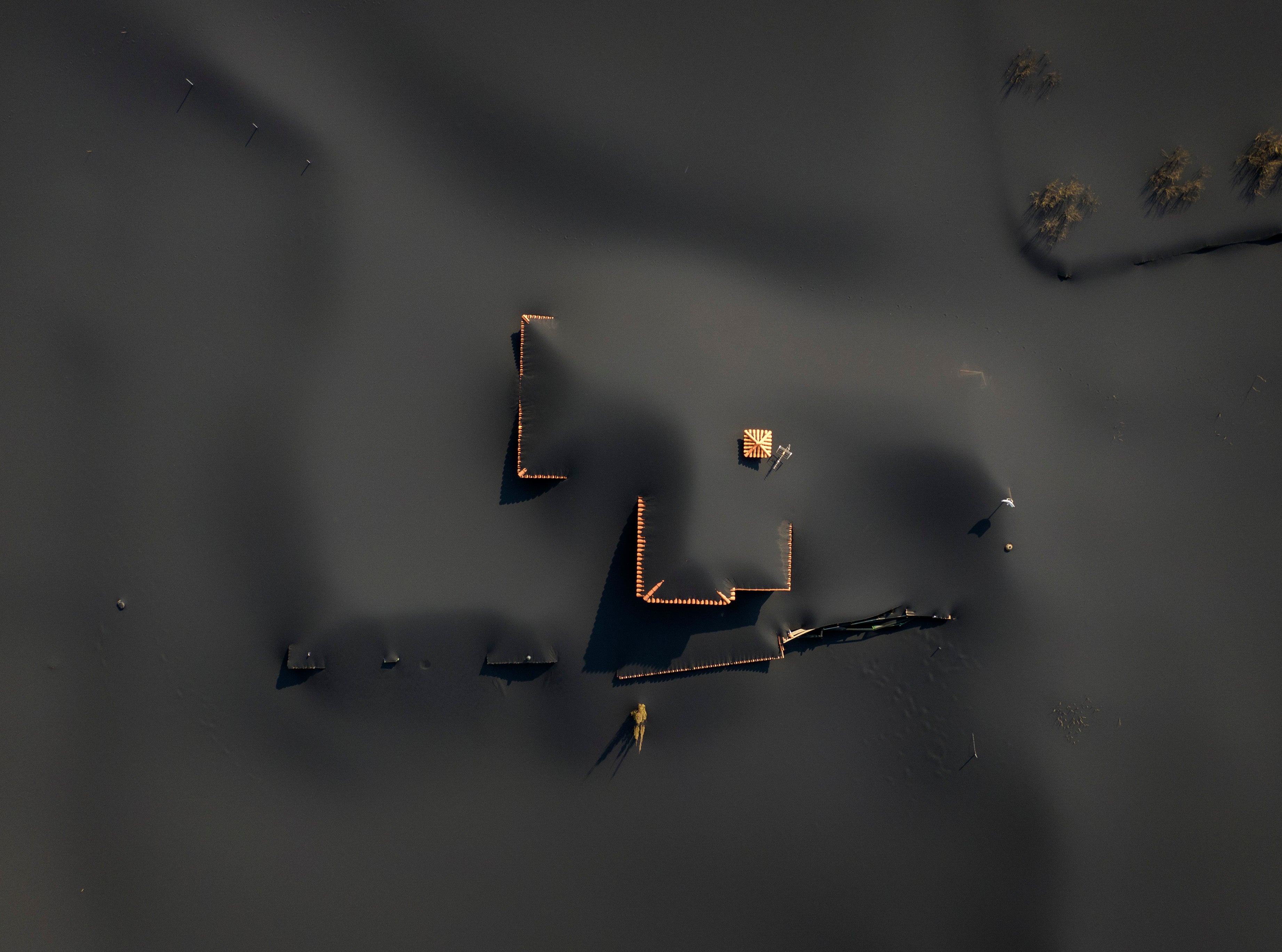 A house is covered by ash from a volcano as it continues to erupt on the Canary island of La Palma, Spain, Saturday, Oct. 30, 2021. An erupting volcano in the Spanish island of La Palma continued to emit vast amounts of magma, gases and ash on Saturday, after days of intense seismic activity and more than five weeks since it erupted. (AP Photo/Emilio Morenatti)