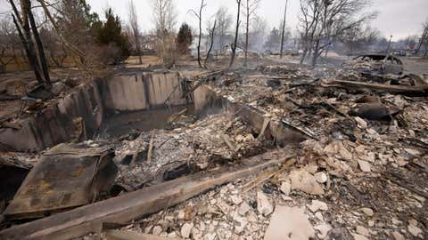 Debris surrounds the remains of homes set on fire by wildfires after destroying a development on Friday, December 31, 2021 in Superior, Colorado. Tens of thousands of Coloradans have been driven from their neighborhoods by wind-blown forest fires. (AP Photo / David Zalubowski)