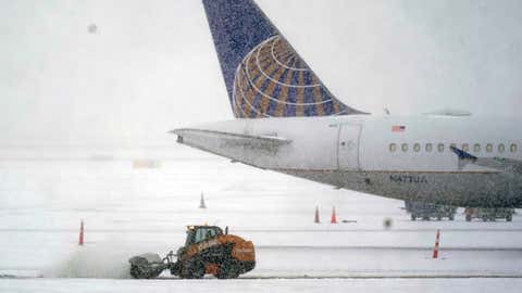 Snow and ice are removed outside a parked plane at Dallas-Fort Worth International Airport in Grapevine, Texas, Thursday, Feb. 3, 2022. (AP Photo/LM Otero)