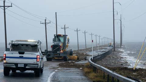 Highway crews clean debris caused by Fiona on the Les Îles-de-la-Madeleine, Quebec, Saturday, Sept. 24, 2022. (Nigel Quinn/The Canadian Press via AP)