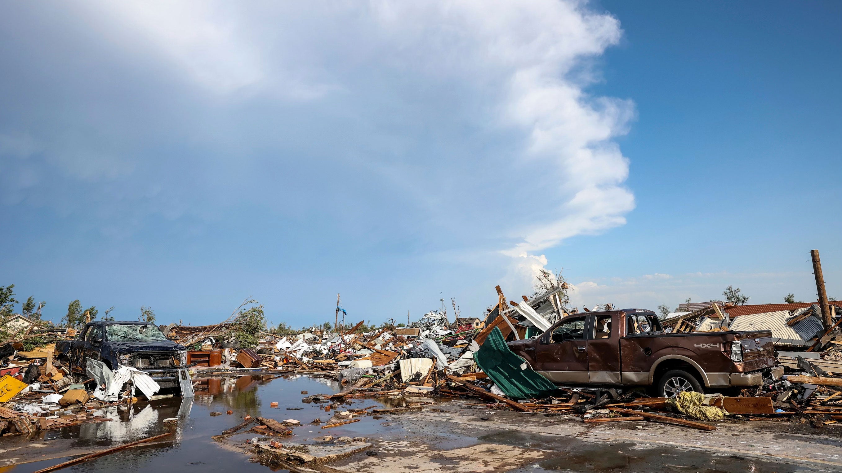 Damaged pickup trucks sit among debris after a tornado passed through a residential area in Perryton, Texas, Thursday, June 15, 2023. (AP Photo/David Erickson)
