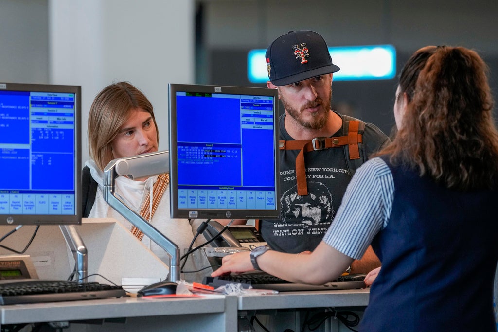 A airline agents helps a travelers in the departures area of Terminal B at LaGuardia Airport, Tuesday, June 27, 2023, in New York.  Travelers waited out widespread delays at U.S. airports on Tuesday, an ominous sign heading into the long July 4 holiday weekend, which is shaping up as the biggest test yet for airlines that are struggling to keep up with surging numbers of passengers. (AP Photo/Mary Altaffer)