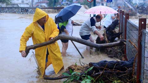 Residents remove debris from a flooded area in the town of Volos, central Greece, Tuesday, September 5, 2023. A man was killed when police ordered vehicles off the streets of three regions in Greece, Tuesday, as a severe storm raged, the fire department says. It hit the center of the country and some of its islands, turning the streets into torrents that flooded and swept cars into the sea. (George Kidonas/Intime News via AP)