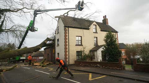 Pracownicy usuwają powalone drzewo, które uszkodziło dach domu we wsi Stanley w Derbyshire w Anglii, czwartek, 21 grudnia 2023 r. Oczekuje się, że burza Pia spowoduje zakłócenia w niektórych częściach Szkocji, północnej Anglii i Irlandii Północnej. .