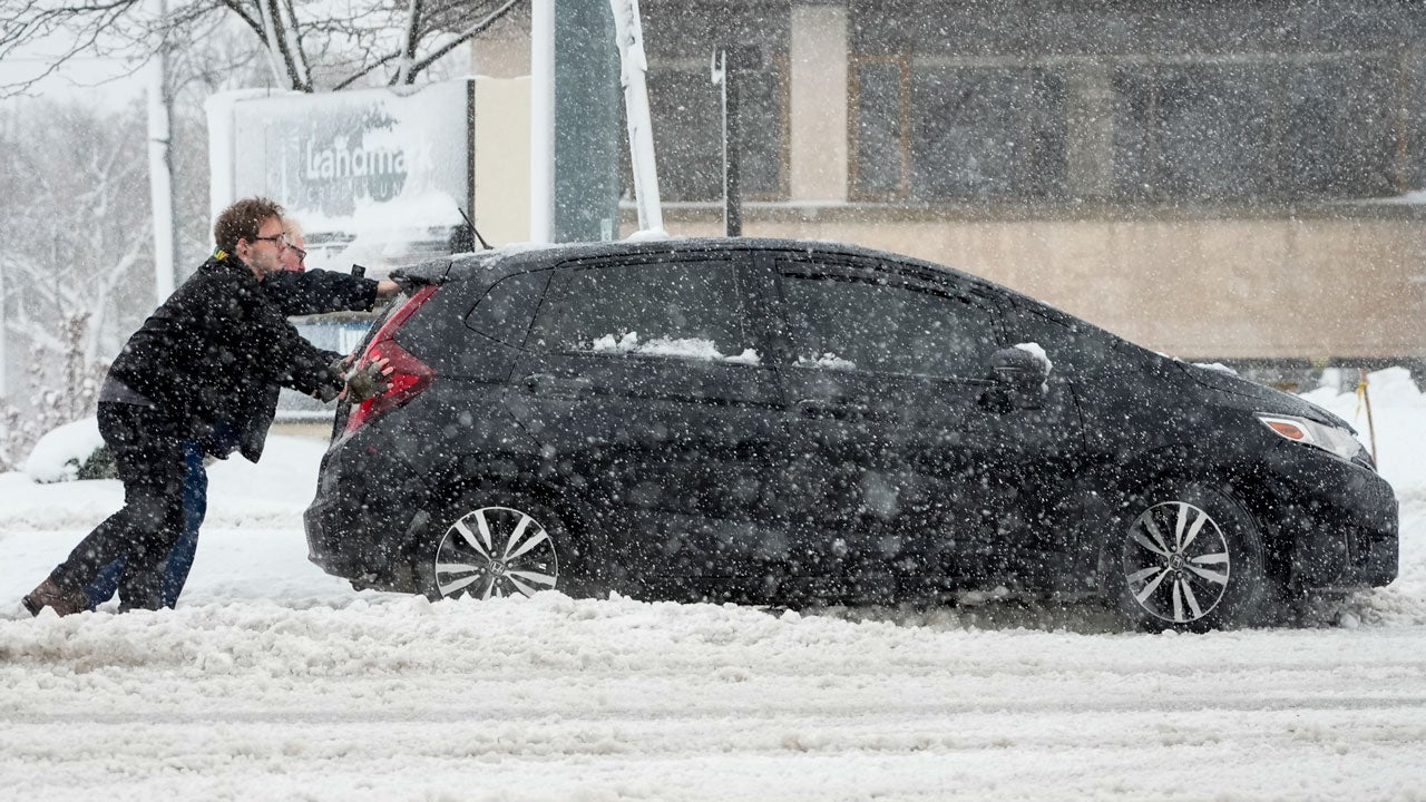 People push a car out of a snowbank as a winter storm arrives Friday, Jan. 12, 2024, in West Allis, Wisconsin. (AP Photo/Morry Gash)