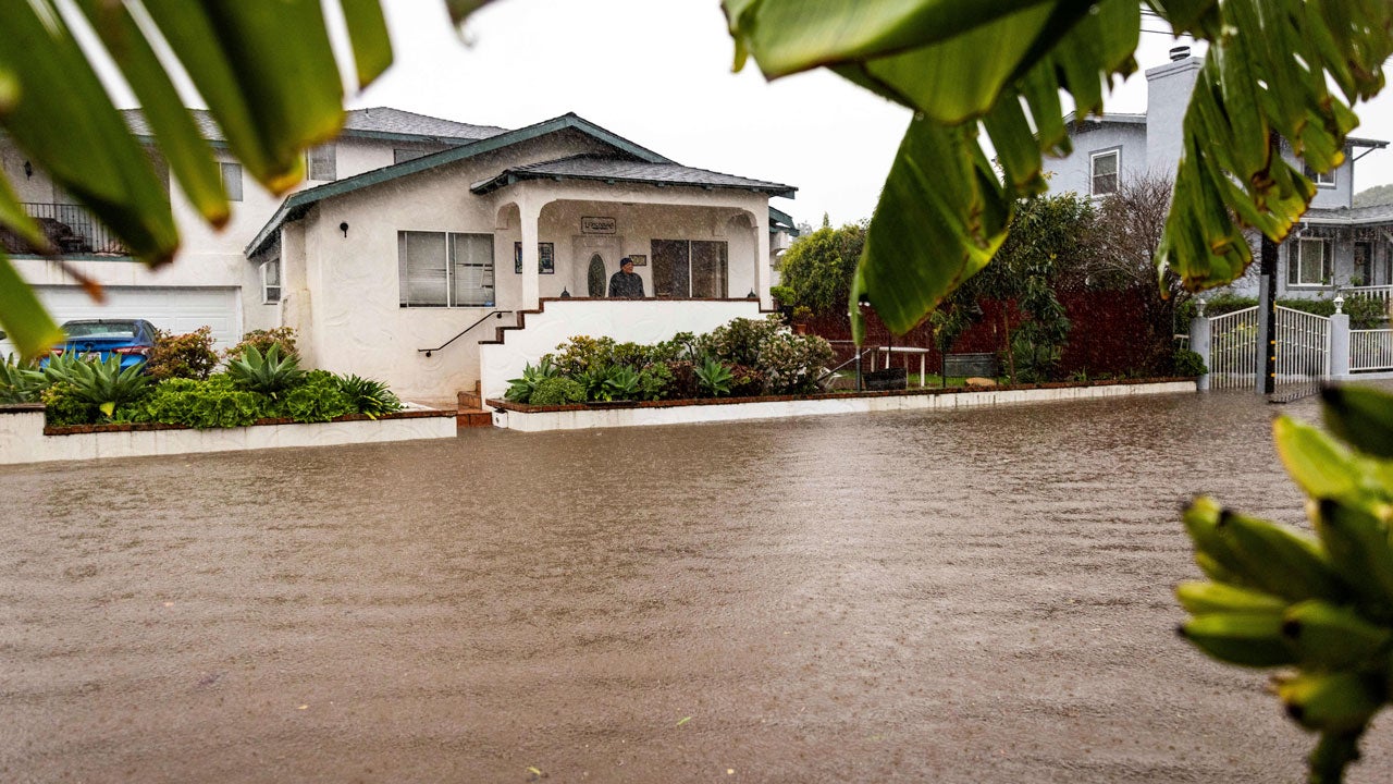 A resident watches as floodwaters rise during a rainstorm, Sunday, Feb. 4, 2024, in Santa Barbara, California. (AP Photo/Ethan Swope)