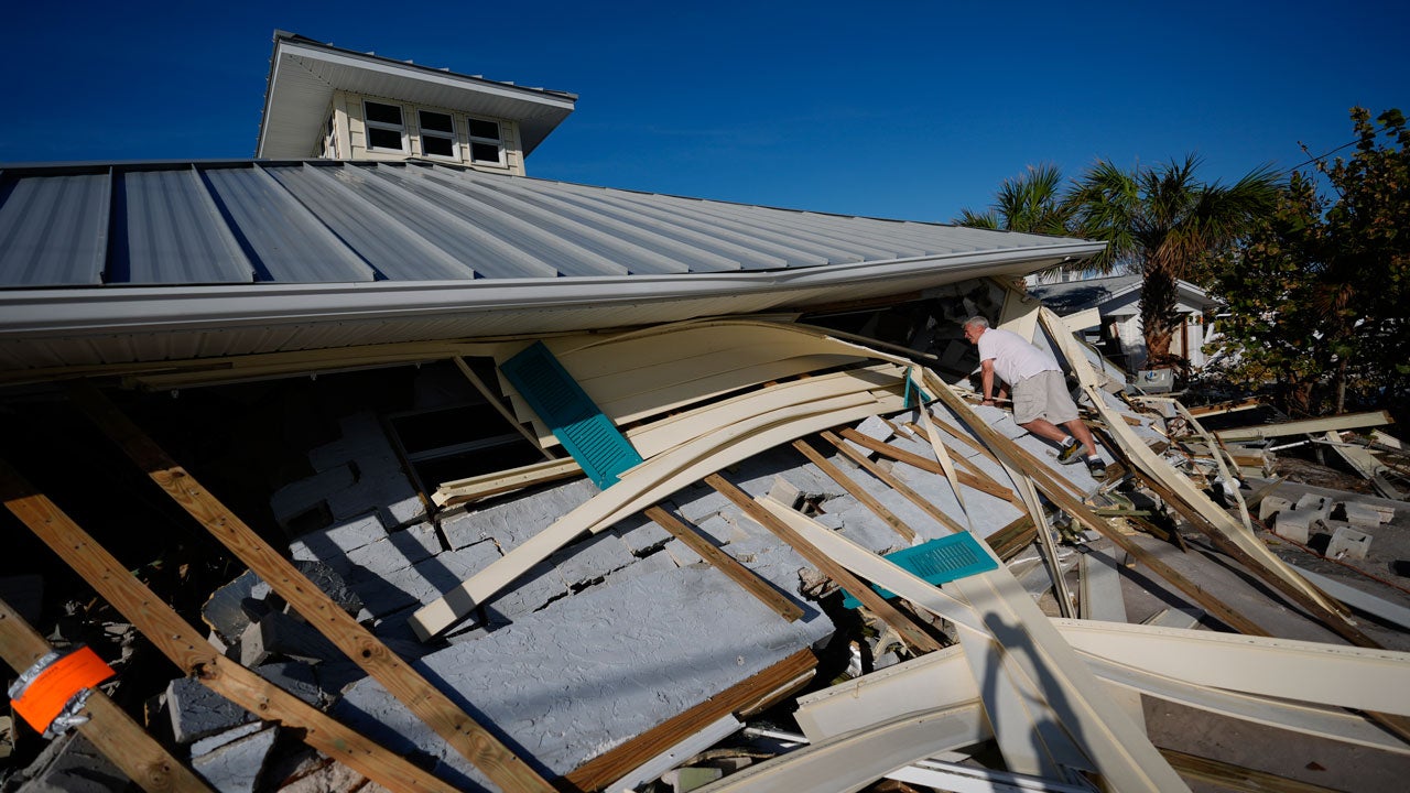 A property owner who preferred not to give his name peers into the remains of the second-floor unit where he lived with his wife while renting out the other units, on Manasota Key, in Englewood, Florida, following the passage of Hurricane Milton, Sunday, Oct. 13, 2024. (AP Photo/Rebecca Blackwell)