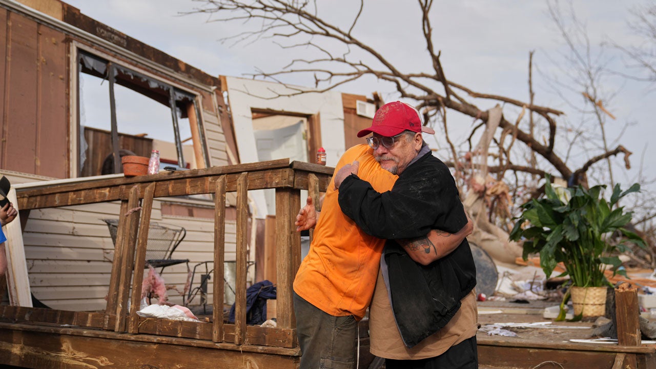 Tim Scott, right, gets a hug from friend Jorden Harris outside Scott's home he was inside when it was destroyed during a severe storm the evening before Saturday, March 15, 2025, in Wayne County, Missouri. (AP Photo/Jeff Roberson)