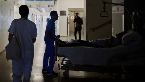 A medical staffer relocates a patient during a nationwide power outage in Pamplona, northern Spain, on Monday, April 28, 2025. (AP Photo/Miguel Oses)