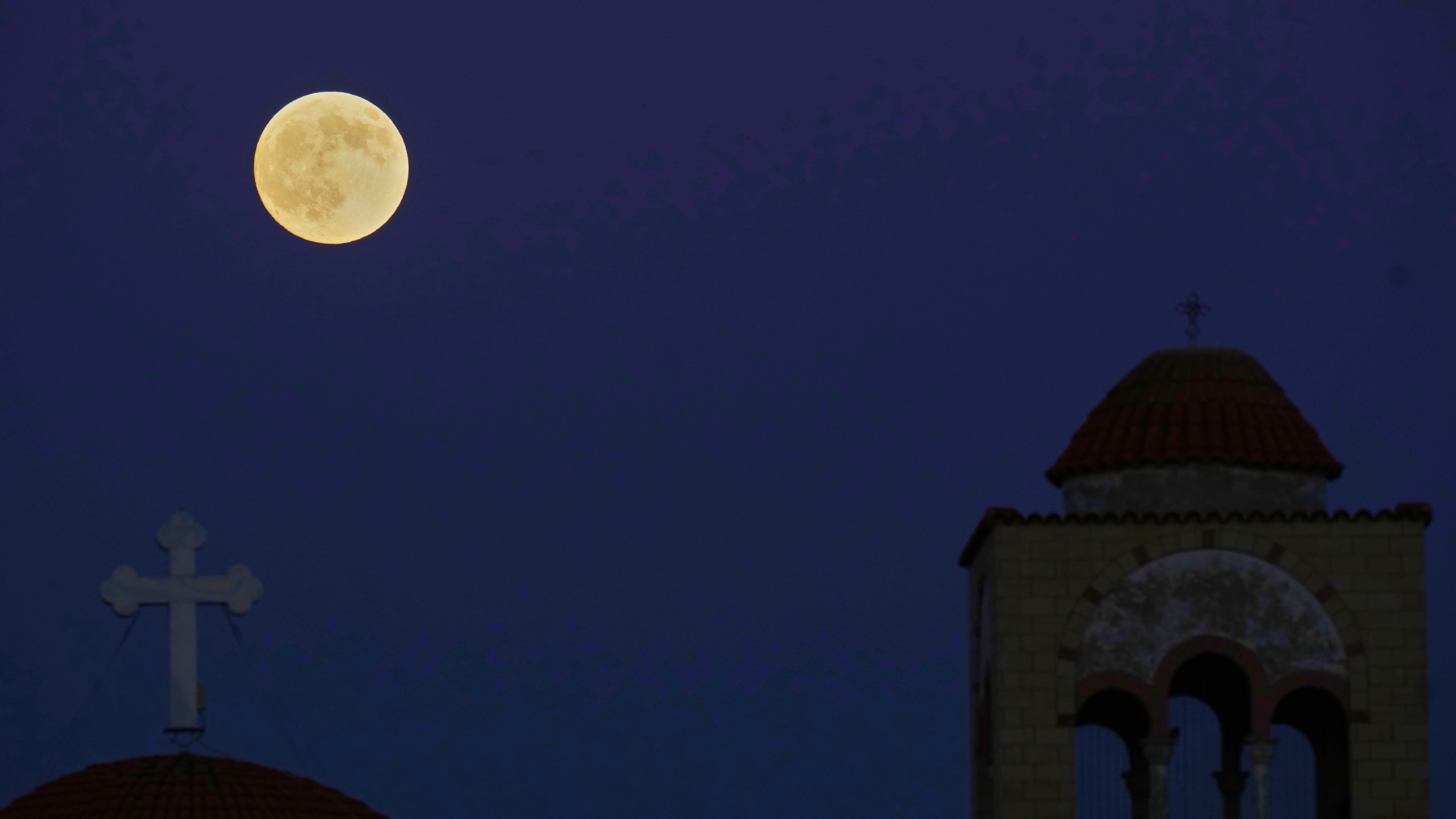 The Harvest Supermoon rises behind the 'Metamorphosis Sotiros' Christian Orthodox Church at Anthoupolis outskirts of capital Nicosia, Cyprus.