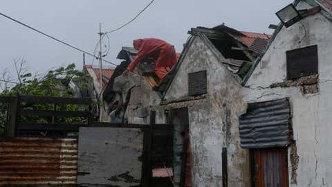 Men remove a loose section of roof in Kingston, Jamaica, as Hurricane Melissa approaches, Tuesday, Oct. 28, 2025. (AP Photo/Matias Delacroix)