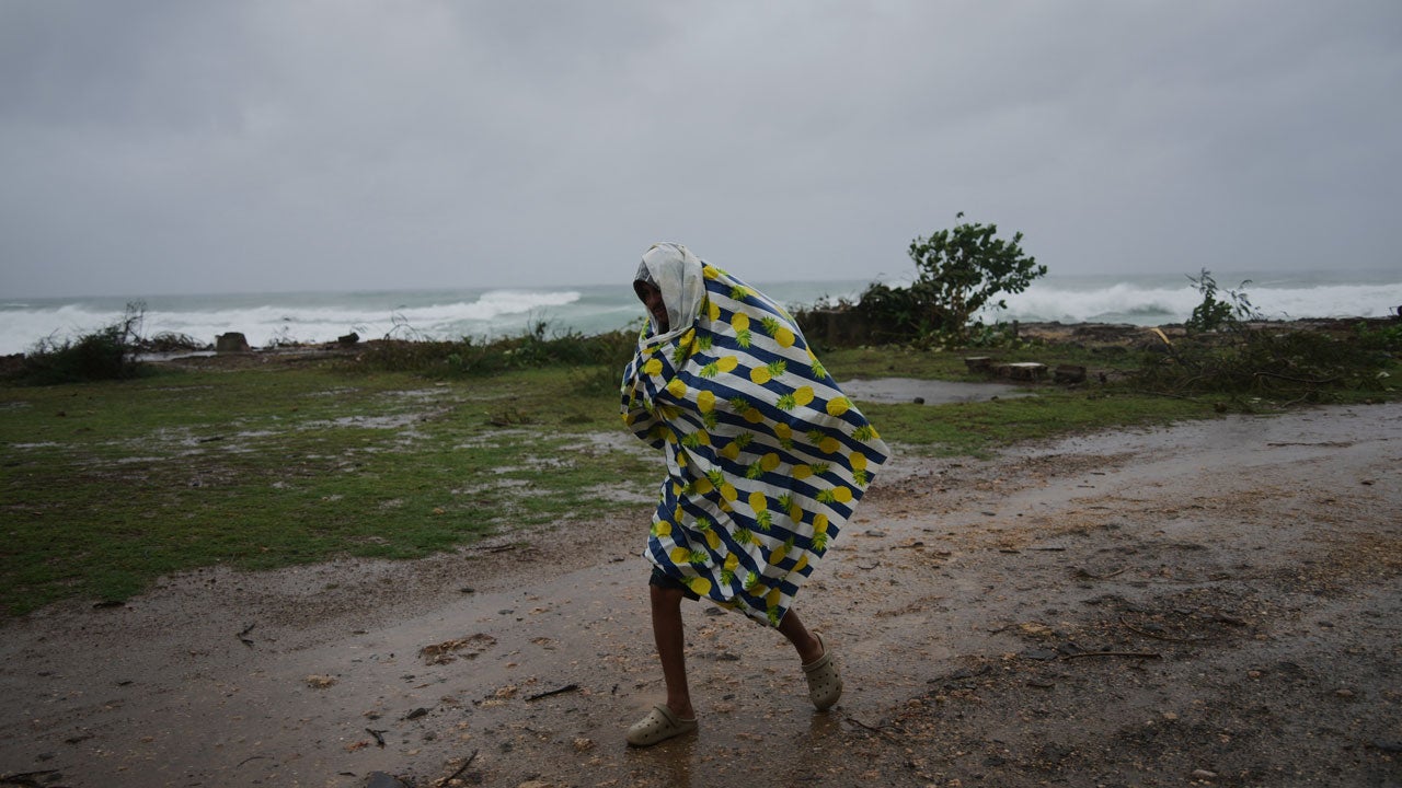 A man walks in the rain before the arrival of Hurricane Melissa in Canizo, a village in Santiago de Cuba, Tuesday, Oct. 28, 2025. (AP Photo/Ram&oacute;n Espinosa)