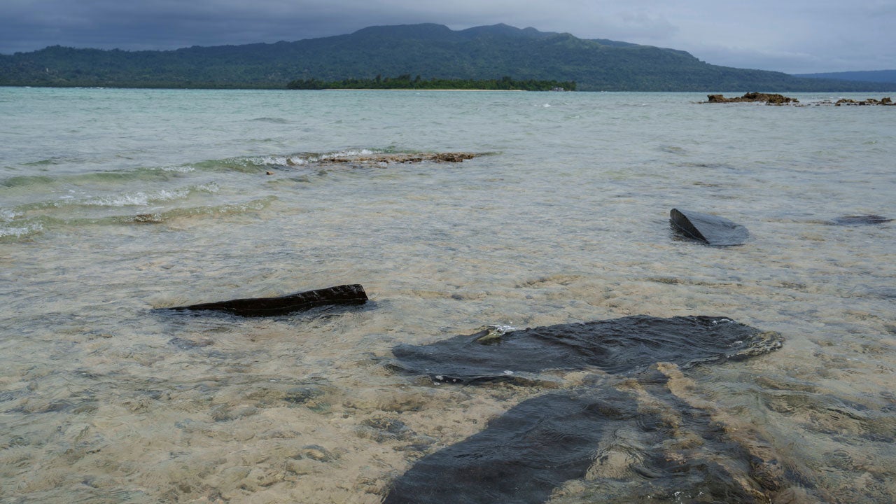 Gravestones sit submerged in water on Pele Island, Vanuatu, a country heavily affected by rising seas, July 18, 2025. (AP Photo/Annika Hammerschlag, File)