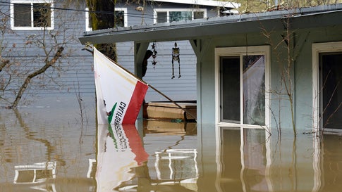 A California state flag hangs from the front of a home submerged in the flood waters of the Russian River in Forestville, Calif., on Wednesday, Feb. 27, 2019. The still rising Russian River was engorged by days of rain from western U.S. storms. (AP Photo/Michael Short)