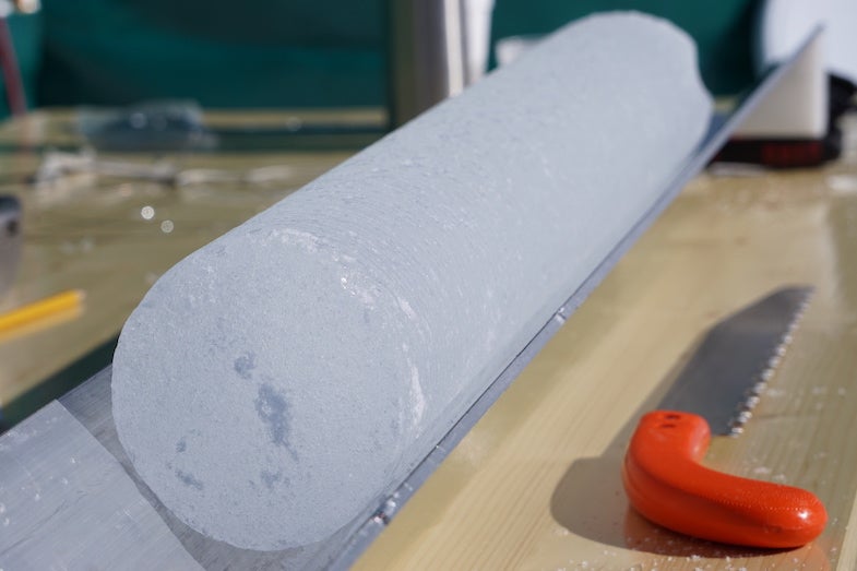 An ice core sits in the aluminum trough for processing and bagging