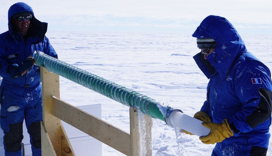Nico Caillon receives an ice core as Phillipe Possenti raises the drill bit.