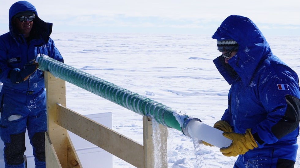 Nico Caillon receives an ice core as Phillipe Possenti raises the drill bit.