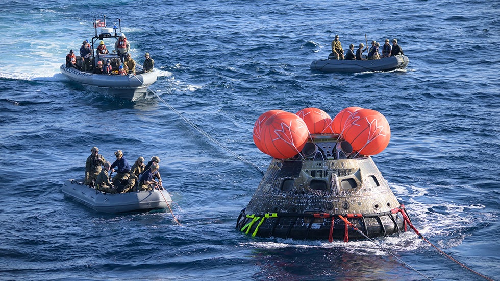 After splashing down on Dec. 11, 2022, U.S. Navy divers help recover the Orion spacecraft for the Artemis I mission. During this uncrewed flight, designated Artemis I, the spacecraft traveled thousands of miles beyond the Moon and then back to Earth over the course of about three weeks. (NASA/Josh Valcarcel)