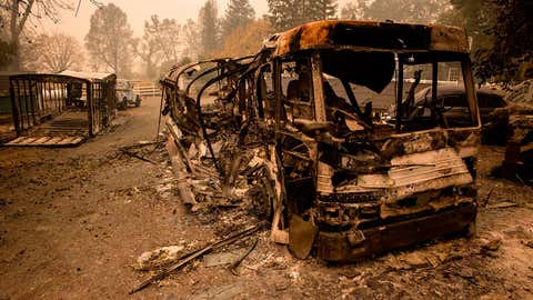 Vehicles burned in the Glass Fire sit outside of a home that survived in Calistoga, Napa Valley, California on September 30, 2020. - Two California wildfires that ravaged Napa's famous wine region and killed three people exploded in size Tuesday as firefighters faced a weeks-long battle to contain the blazes. (Photo by Samuel Corum / AFP) (Photo by SAMUEL CORUM/AFP via Getty Images)
