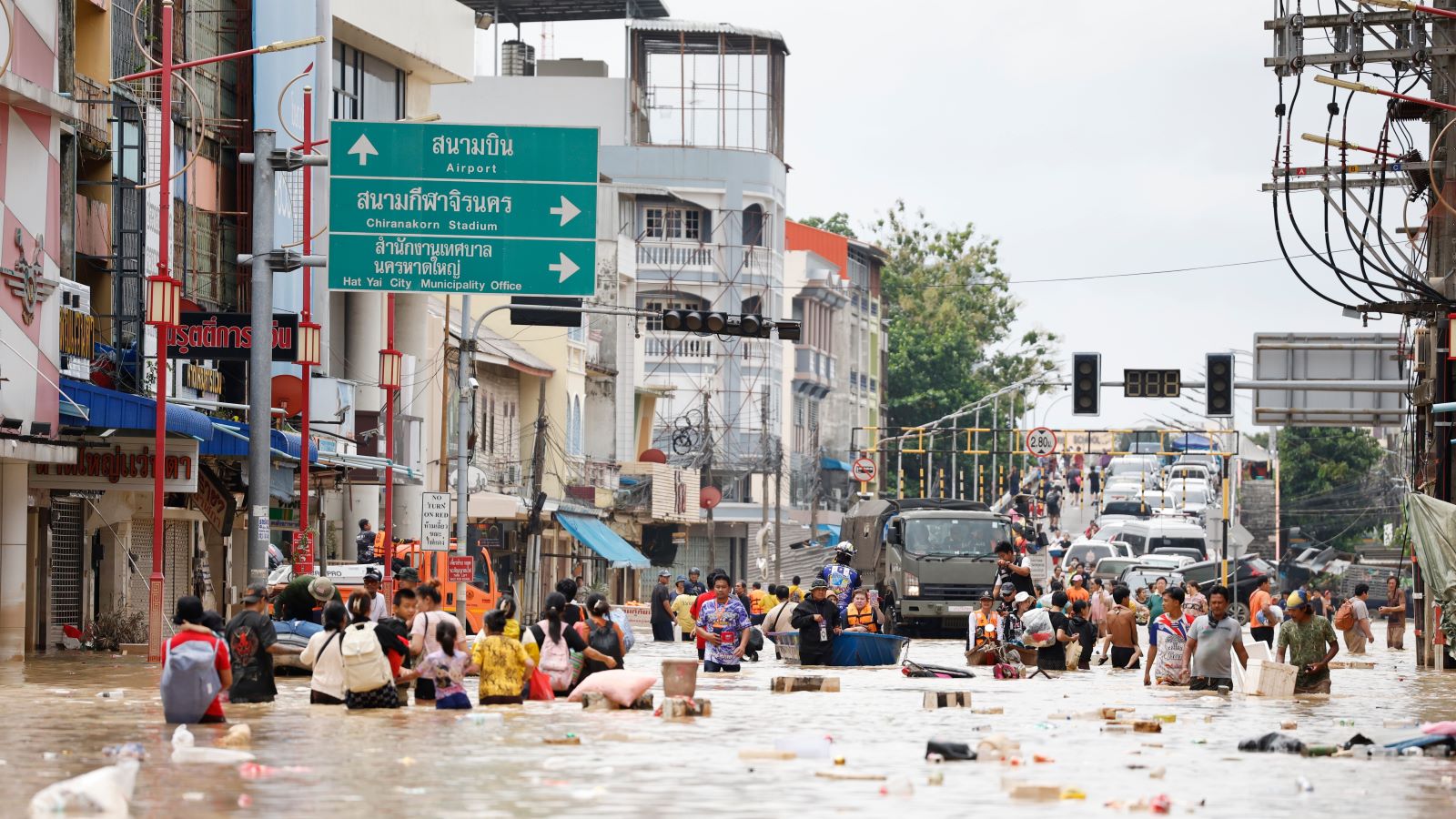 27.11.2025, Thailand, Songkhla: Menschen waten durch das Hochwasser in der Provinz Songkhla im S&uuml;den Thailands. Foto: Sarot Meksophawannakul/AP/dpa +++ dpa-Bildfunk +++