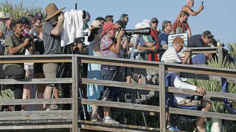 Visitors at Playalinda Beach look on as the SpaceX Falcon Heavy rocket launches from Pad 39B at the Kennedy Space Center in Florida, on April 11, 2019. - SpaceX's Falcon Heavy ferried the Arabsat-6A communications satellite into orbit for Saudi Arabia in the first commercial mission of the world's most powerful rocket. The Falcon Heavy consists of three first-stage boosters based on SpaceX's Falcon 9 rockets, all of which are designed to return to Earth under power for later reuse. The Arabsat-6A is a 6,000 kg (13,227 lbs) satellite that will provide telecommunications access throughout the Middle East, Europe and Africa. It is also a milestone flight for SpaceX, marking the first launch with a paying customer: Saudi Arabia. (Photo by Gregg Newton / AFP)        (Photo credit should read GREGG NEWTON/AFP via Getty Images)