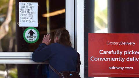 A customer peers in a closed Safeway grocery store which is closed after the power was shut down as part of a statewide blackout in Santa Rosa, California on October, 10, 2019. - Rolling blackouts set to affect millions of Californians began October 9, as Pacific Gas & Electric started switching off power to an unprecedented number of households in the face of hot, windy weather that raises the risk of wildfires. PG & E, which announced the deliberate outage, is working to prevent a repeat of a catastrophe last November in which faulty power lines it owned were determined to have sparked California's deadliest wildfire in modern history. (Photo by Josh Edelson / AFP) (Photo by JOSH EDELSON/AFP via Getty Images)