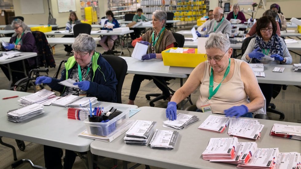 Election workers wearing protective gloves in Renton, WA, 3/9/20