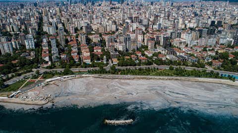 This aerial photograph taken on June 6, 2021, in Turkey's Marmara Sea at a harbor on the shoreline of Istanbul shows mucilage, a jelly-like layer of slime that develops on the surface of the water due to the excessive proliferation of phytoplankton, gravely threatening the marine biome. The mucilage has been informally referred to as "sea snot" and was first documented in Turkey's waters in 2007. Experts warn the mucilage will occur more often because of global warming. (Yasin Akgul/AFP via Getty Images)