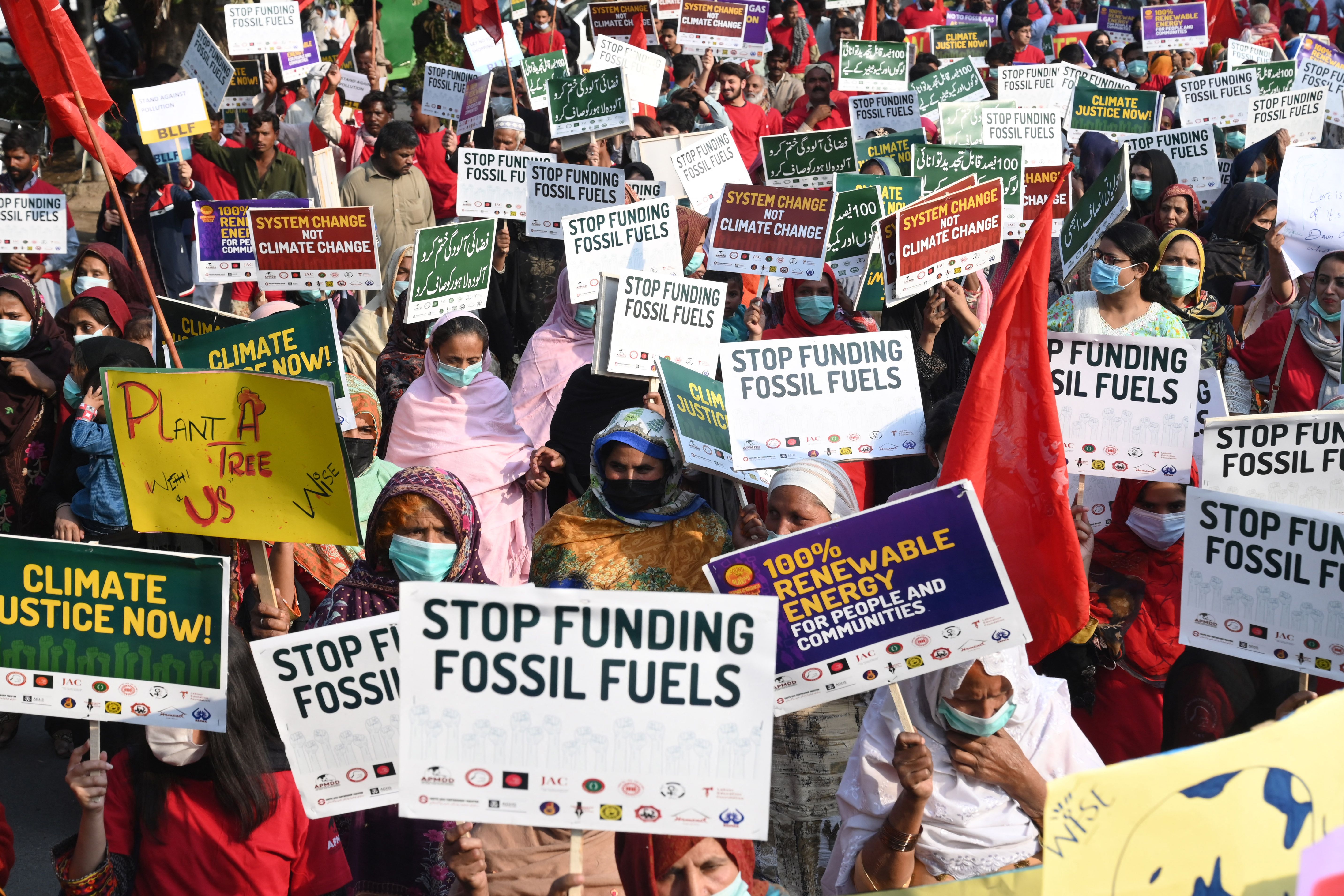 Human rights activists hold placards during a protest in connection with the COP26 UN Climate Change Conference, in Lahore on Nov. 8, 2021. (Arif Ali/AFP via Getty Images)