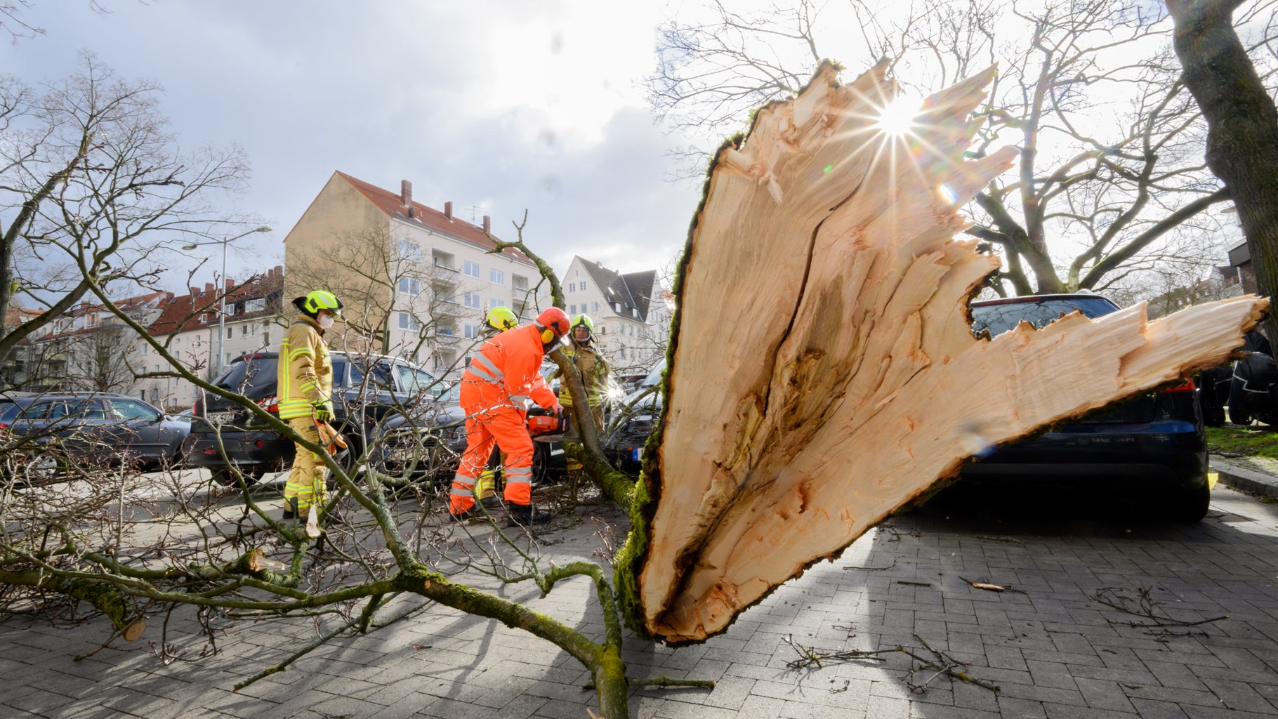 Firefighters free cars from branches that crashed into a parking lot during Storm Dudley in Hanover, Germany, on Thursday, Feb. 17, 2022. (Photo by Julian Stratenschulte/picture alliance via Getty Images)