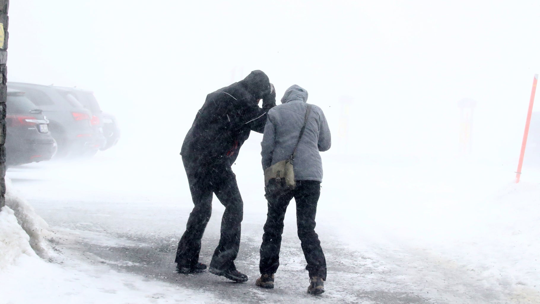 Visitors are seen on the Fichtelberg in stormy weather in Saxony, Germany, on Thursday, Feb. 17, 2022. (Photo by Bodo Schackow/picture alliance via Getty Images)