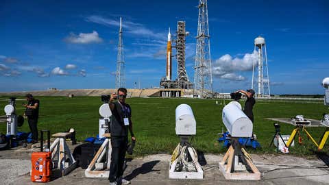 People set up a remote camera near the Artemis I rocket behind the launch pad at Kennedy Space Center in Cape Canaveral, Florida, September 1, 2022. - NASA will make his second attempt to launch a powerful new moon rocket on September 3rd. , after scrubbing test flights earlier in the week. The long-awaited unmanned mission will bring the United States one step closer to returning an astronaut to the moon 50 years after man last walked on the moon. (Photo by CHANDAN KHANNA/AFP) (Photo by CHANDAN KHANNA/AFP via Getty Images)