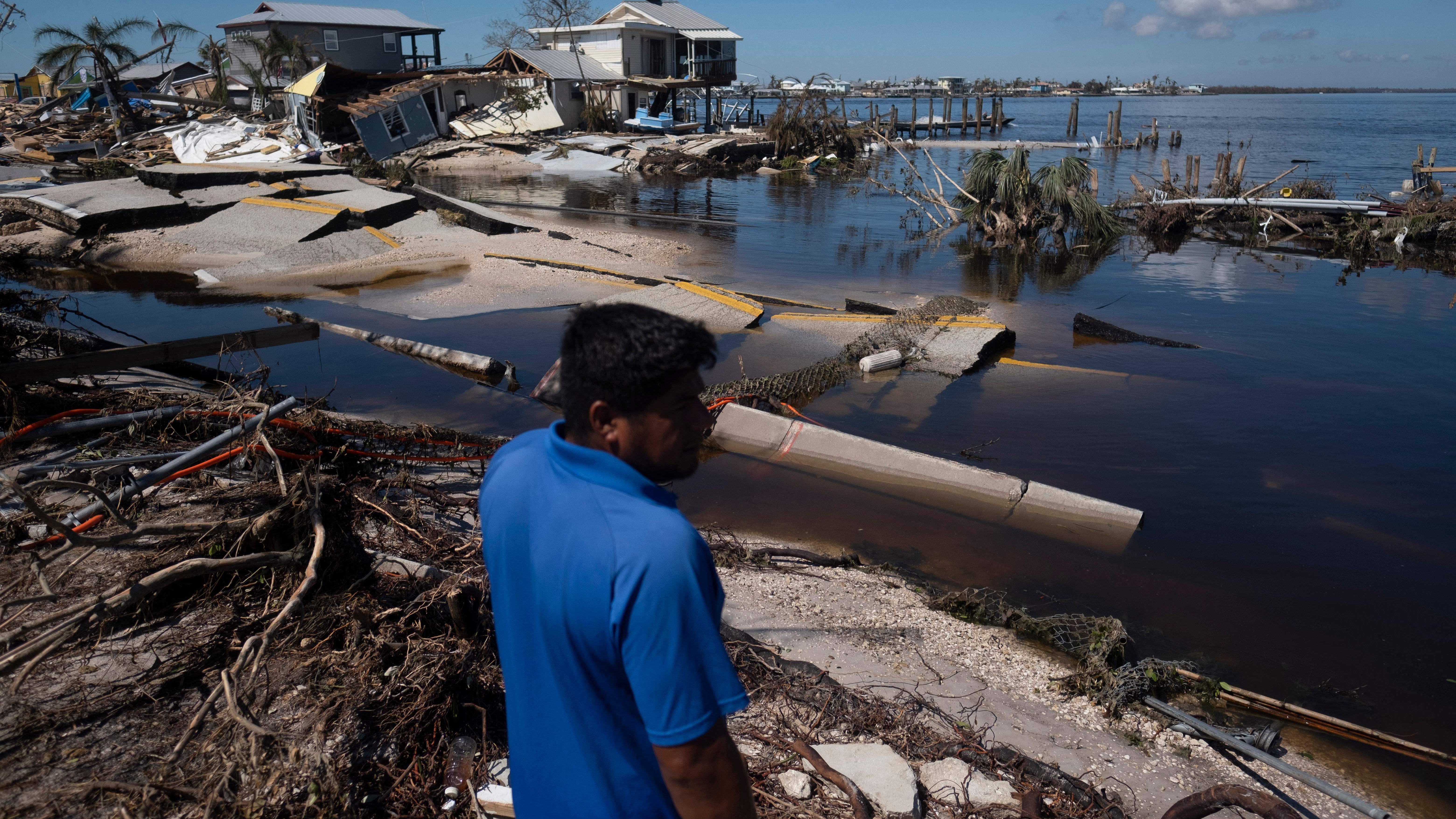 A man looks among destroyed houses on in the aftermath of Hurricane Ian in Matlacha, Florida on October 1, 2022. - Shocked Florida communities counted their dead October 1, 2022, as the full scale of the devastation came into focus, two days after Hurricane Ian tore into the coastline as one of the most powerful storms ever to hit the United States. (Photo by Ricardo ARDUENGO / AFP) (Photo by RICARDO ARDUENGO/AFP via Getty Images)