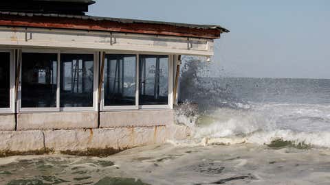 Las olas rocían agua sobre las estructuras costeras de Kalk Bay en Ciudad del Cabo el 17 de septiembre de 2023 tras la marea alta primaveral en la provincia de Cabo Occidental.  (Foto de GIANLUIGI GUERCIA/AFP) (Foto de GIANLUIGI GUERCIA/AFP vía Getty Images)