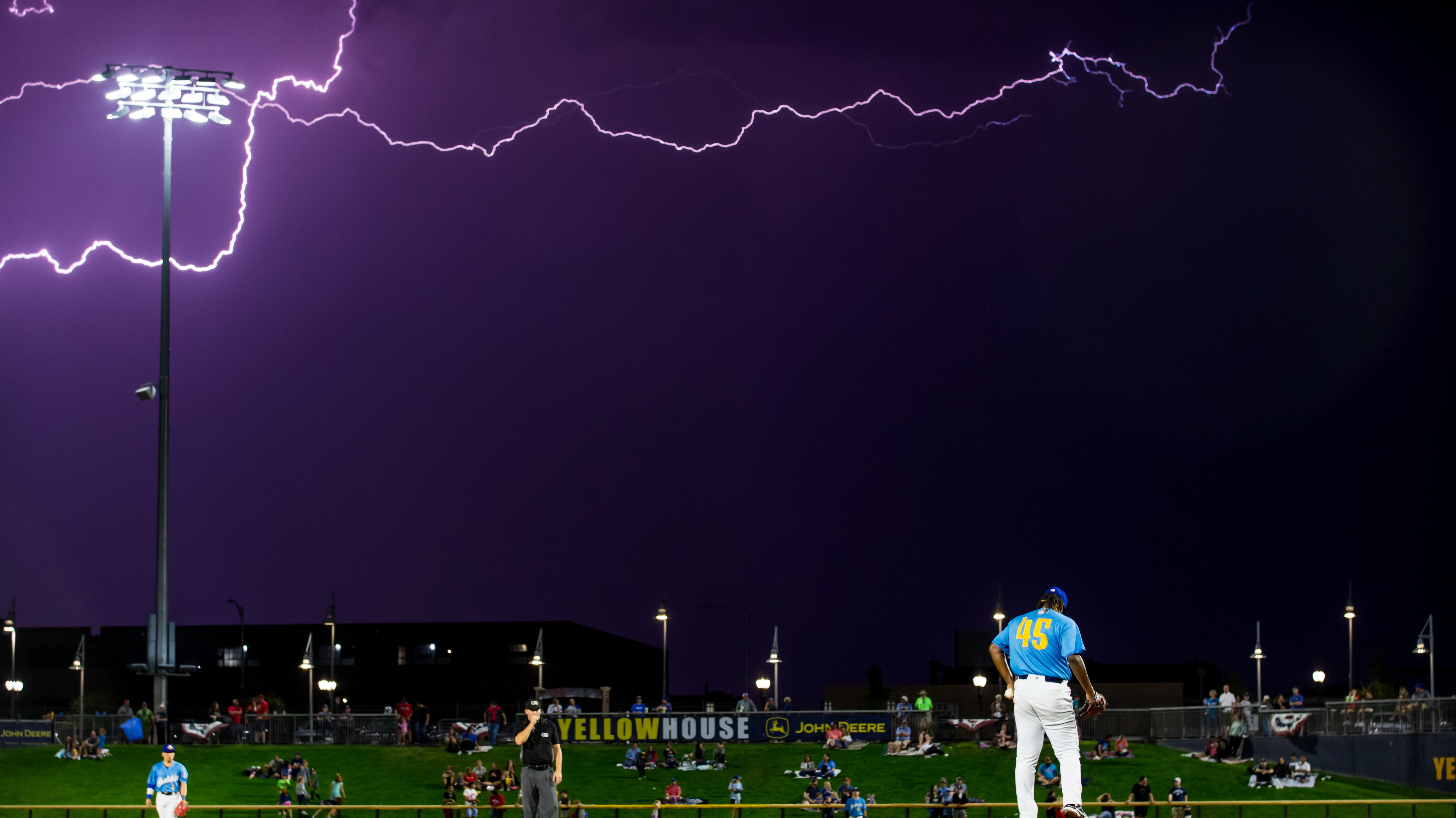 AMARILLO, TEXAS - SEPTEMBER 27: Emailin Montilla #45 of the Amarillo Sod Poodles pitches as lightning strikes to the east during the Texas League Championship game against the Arkansas Travelers on Wednesday, September 27, 2023, at HODGETOWN in Amarillo, Texas. (Photo by John E. Moore III/Getty Images)