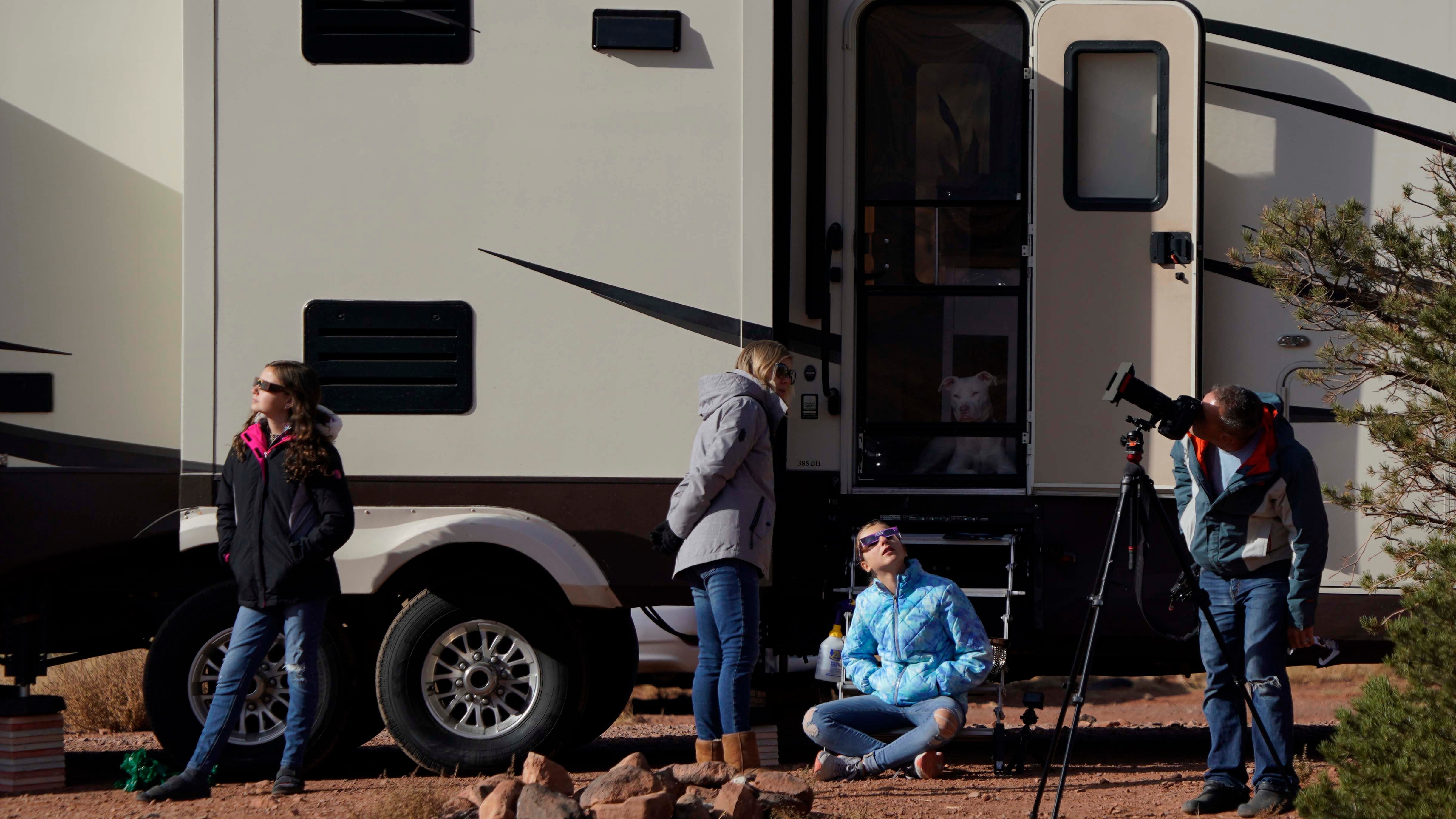 CAPITOL REEF NATIONAL PARK, UTAH - OCTOBER 14: People with solar glasses watch and take pictures of the Annular Solar Eclipse on October 14, 2023 in Capitol Reef National Park, Utah. Starting at the Oregon coast and concluding on the east coast of South America an annular solar eclipse, where the moon is at its farthest from the Earth, will project a halo of sunlight around the moon's border.  (Photo by George Frey/Getty Images)