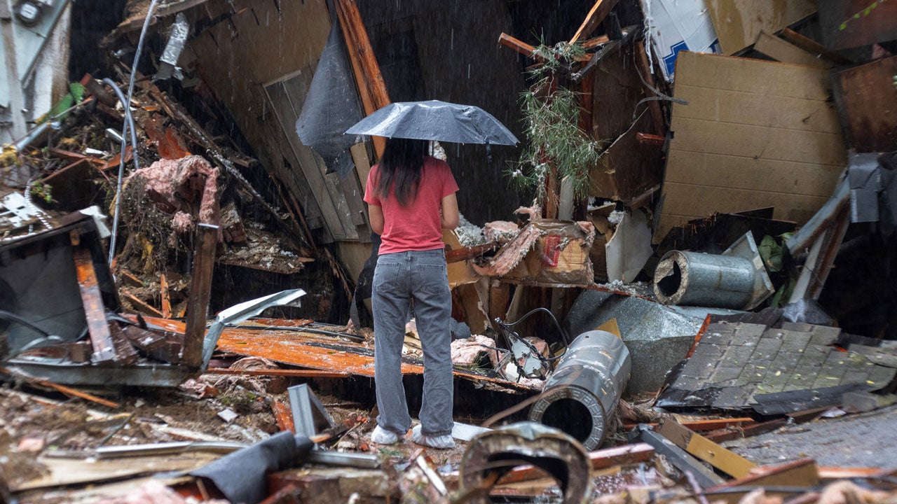 A woman stands among the wreckage of a house that was abruptly destroyed by a landslide after an atmospheric river storm inundated the Hollywood Hills area of Los Angeles, Feb. 6, 2024. (David McNew/AFP via Getty Images)