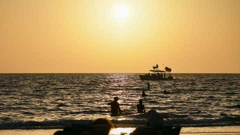 Los visitantes y los amantes de la playa miran la puesta de sol a finales de la tarde en Clearwater Beach, Florida. (Foto de Ronaldo Silva/Nurphoto a través de Getty Images)
