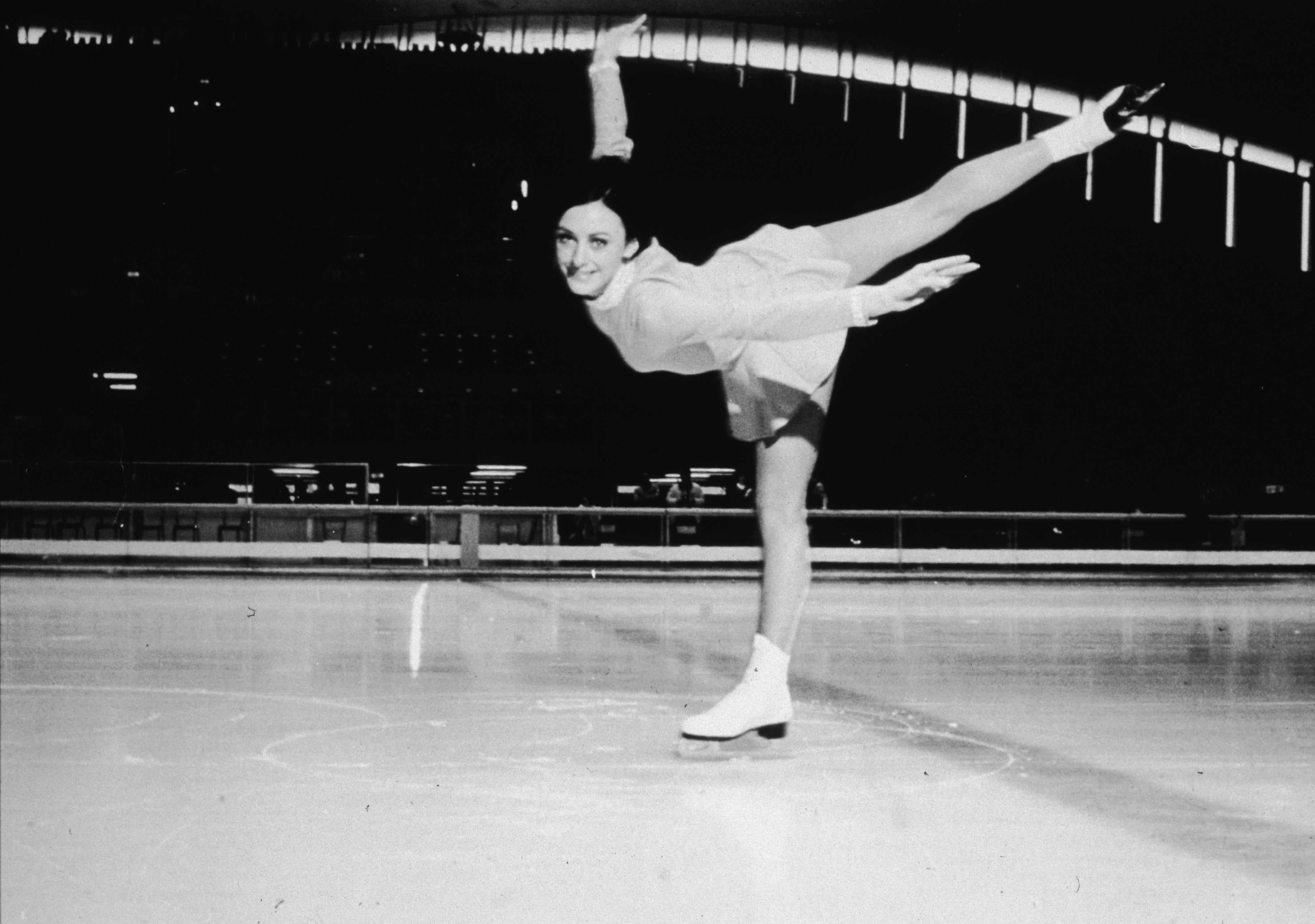 La patinadora artística estadounidense Peggy Fleming ejecuta una espiral en la pista de hielo en los Juegos Olímpicos de Invierno de 1968, donde ganó la medalla de oro en el evento de patinaje artístico femenino el 11 de febrero, Grenoble, Francia, febrero de 1968. (Foto de Hulton Archive/Getty Images)