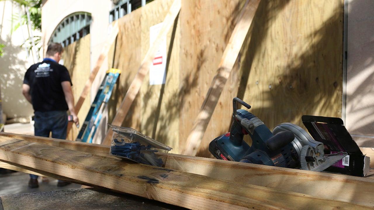 A worker puts reinforcements on boarded storefront windows in the Waikiki neighborhood of Honolulu, Saturday, July 25, 2020, as Hurricane Douglas approaches. President Donald Trump issued an emergency declaration for Hawaii on Saturday because of Douglas, directing federal assistance to supplement state and local response efforts.&nbsp;(AP Photo/Caleb Jones)