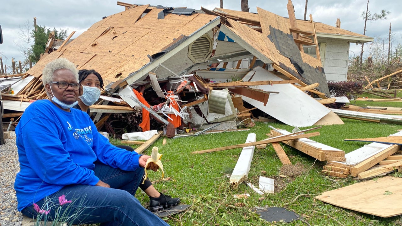 Mamie, left, and Katrina Harper sit near their destroyed home where they rode out the tornado that struck Bassfield, Mississippi on Easter Sunday, April 12, 2020. On Monday they said they are counting their blessings and gathering their belongings. (Julie Dermansky)